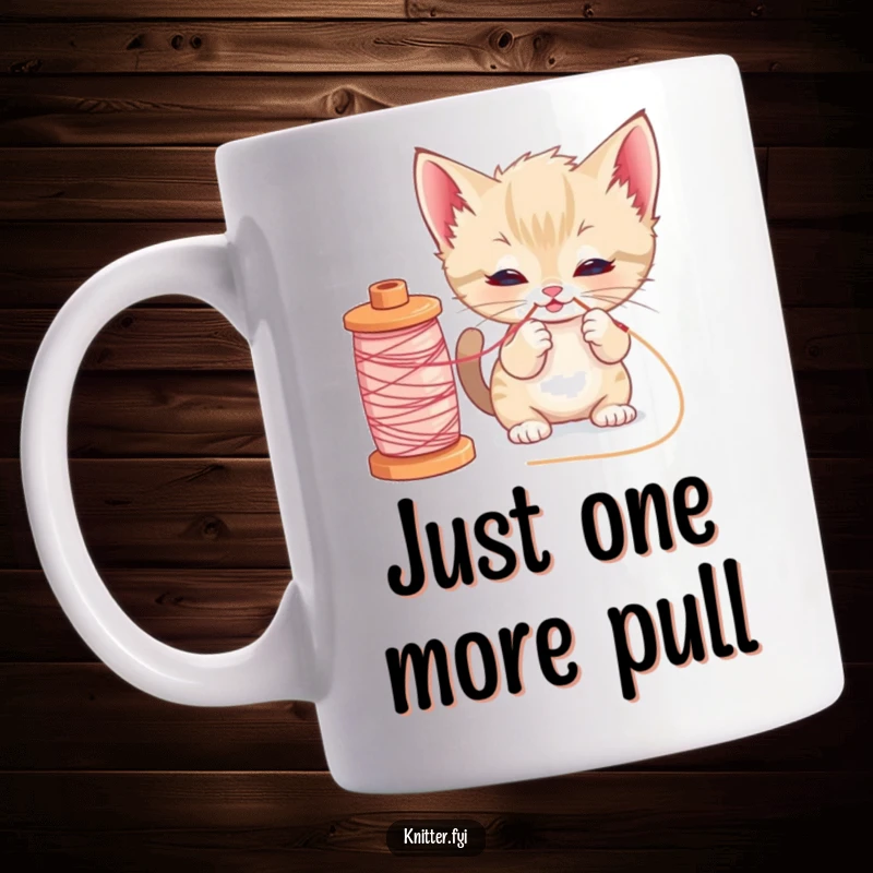 Funny kitten sewing mug with a curious cat playfully pulling a loose thread from a large spool of yarn, showcasing its mischievous charm.