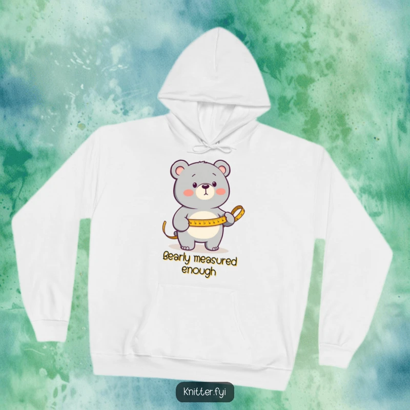 Funny Hoodie featuring a determined bear measuring fabric with a golden measuring tape, designed for comfort and creative spirit.