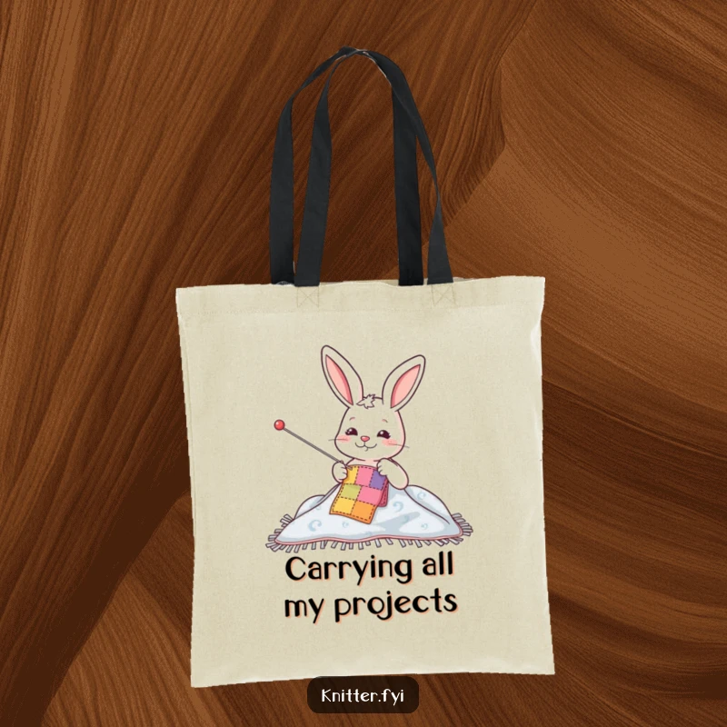 Funny tote bag featuring a happy rabbit character using a large needle to sew a colorful patch on a blanket, perfect for crafters.
