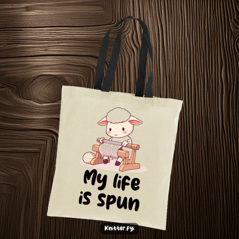 Cute sheep character diligently operating a knitting loom, on a reusable tote bag.